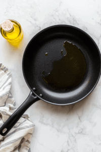 This image shows a large skillet heating over medium-high heat