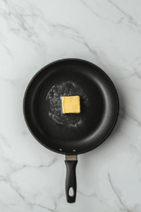 This image shows butter or oil heating in a frying pan