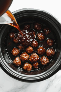 pouring-the-warm-jelly-mixture-over-the-meatballs to add equal flavour and taste in each meatball