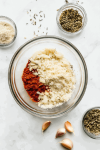 This image shows parmesan cheese being mixed with seasonings to prepare the coating.