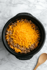 adding-cheddar-cheese-to-the-macaroni which is ready to be cooked