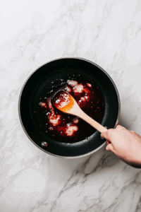 combining-grape-jelly-chili-sauce-and-cayenne-pepper for well mixing of the flavours to make crockpot grape jelly meatballs