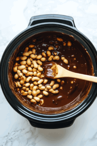 putting-peanuts-in-melted-chocolate to let the peanuts be covered in chocolate completely