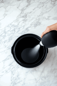 spraying-the-slow-cooker-for-crockpot-candy recipe