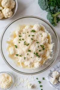 This image shows a creamy dressing being mixed in a bowl with a whisk, combining ingredients to form the perfect topping for the layered salad.