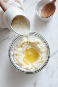 This image shows melted coconut oil being added to the blended crust mixture in a food processor, helping bind the ingredients together.