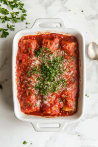 This image shows the finished stuffed cabbage rolls, baked to perfection, with melted cheese and marinara bubbling on top.