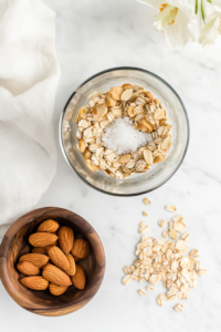 This image shows a food processor blending nuts, dates, and other ingredients to form the crust mixture for the vegan banana cream pie.