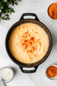 This image shows a blender pureeing the cooked vegetables into a smooth and creamy texture, transforming the ingredients into a luscious vegan broccoli cheese soup.
