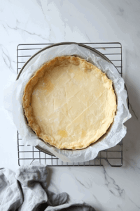 This image shows a freshly baked pie crust being checked for doneness and left to cool completely before adding the filling.
