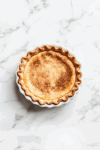 This image shows the Vegan Sugar Cream Pie being placed in the refrigerator to chill, ensuring it firms up perfectly before serving.