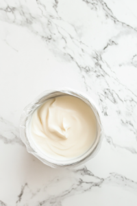 This image shows a bowl of vegan pastry cream cooling at room temperature, ready to be used as a filling for desserts like cakes, tarts, or pastries.