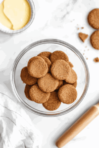 This image shows ginger cookies being crushed into fine crumbs using a food processor, creating the base for the vegan lemon pie crust.