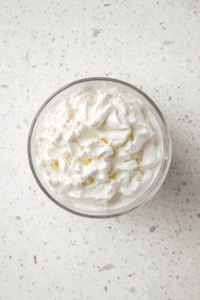 This image shows the smooth and fluffy texture of the final vegan whipped cream, ready to be served and enjoyed.