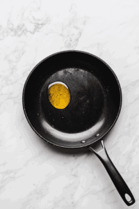 This image shows a skillet with oil being heated, the first step in preparing a flavorful vegetable and pinto bean soup.