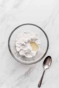This image shows ingredients for the pecan filling, including chopped pecans, maple syrup, and vanilla extract, displayed on a kitchen counter.