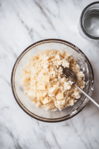 This image shows hands kneading soft, pliable dough on a floured surface, forming the base for the vegan cherry pie.