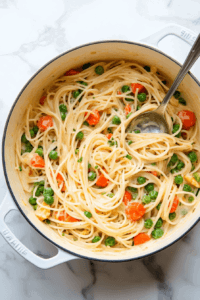 this image shows The one-pot vegan pasta primavera resting in the pot, allowing the creamy sauce to thicken and the flavors to meld together before serving.