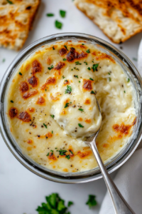 This image shows the cream cheese and mozzarella melted to a smooth consistency in the mixing bowl, forming the base for the fathead pizza dough.