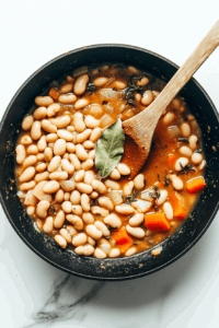This image shows a bouillon cube being dissolved in water to create a flavorful broth for the vegetable and pinto bean soup.