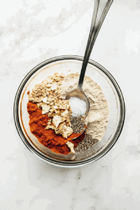 This image depicts a bowl filled with dry ingredients being stirred together to create the perfect base for the dough.