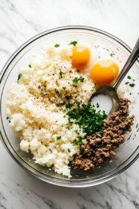 This image shows a bowl with ground meat, cooked rice, and sautéed vegetables being mixed together for the stuffing.