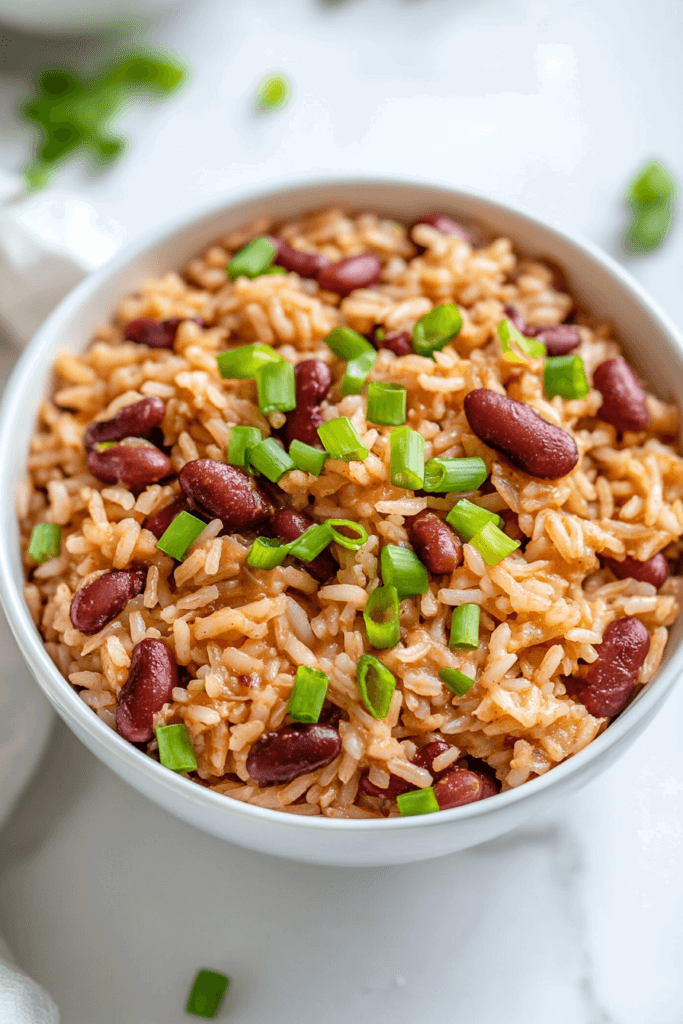 this image shows A flavorful New Orleans-style dish featuring red beans and rice, topped with fresh spring onions for added texture.