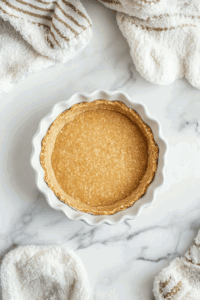 This image shows the partially baked pie crust, golden and ready to be filled with the rich coconut milk filling for the Vegan Sugar Cream Pie.