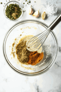 This image showcases a bowl of spices and seasonings being mixed to create a bold and savory marinade for the tofu strips.