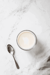 This image shows a pot of vegan condensed milk being gently simmered and thickened, a key ingredient for the rich and creamy lemon pie filling.