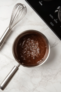 This image shows a saucepan with ingredients being whisked together to create the creamy pudding filling for the vegan banana cream pie.