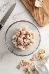 This image shows raw shrimp being prepared and deveined, ready to be cooked into the flavorful Garlic Honey Lime Shrimp dish.