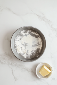 This image shows a round cake tin being lined with a layer of dough, ensuring an even base for the Vegan Linzer Torte.