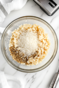 This image shows a bowl with a low-carb crumb mixture being prepared, ready to coat the shrimp before air frying.