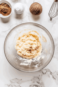 This image shows all the ingredients for the sweet potato pie filling being whipped together in a mixing bowl, forming a velvety smooth mixture.