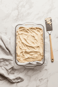 this image shows the prepared crust mixture being pressed evenly into a glass pie dish, creating a sturdy base for the chocolate truffle filling.