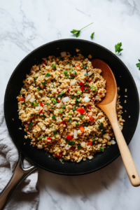 This image shows a skillet with sautéed ground meat, onions, garlic, and seasonings, forming the flavorful base of the stuffing mixture.