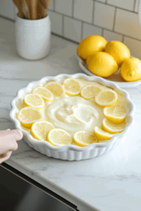 This image shows a freshly filled vegan lemon pie placed in the refrigerator, allowing it to chill and firm up before serving.