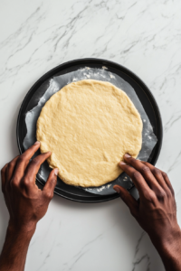 shaping-fathead-dough-with-wet-hands-to-prepare-the-pizza-crust