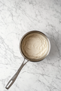 This image shows the sauce being simmered in a pan, ready to be drizzled over the Keto Sheet Pan Shrimp.
