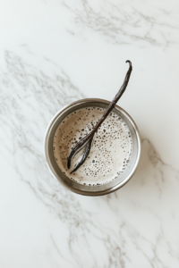 This image shows the soy milk mixture simmering in a saucepan with the vanilla pod floating on top, as the ingredients blend together to create a flavorful custard base.