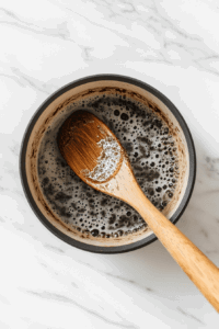 this image shows dark chocolate melting into a warm mixture of coconut milk and oil, combined with vanilla and cinnamon, creating a velvety filling for the chocolate truffle pie.