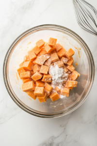 This image shows a mixing bowl filled with sweet potato, brown sugar, and spices, ready to be blended into a smooth filling.