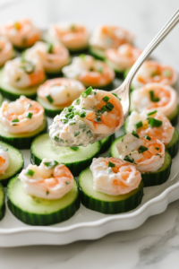 This image displays cucumber slices topped with shrimp salad and garnished with spring onion, ready to be served as shrimp cucumber bites.
