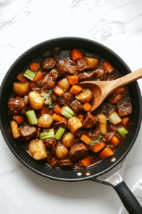 This image shows sautéed vegetables being carefully transferred from a skillet to a saucepan, preparing them for the addition of beans and broth.