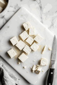 This image depicts tofu strips with corners being trimmed for a more rounded, authentic chicken tender shape, adding an aesthetic touch.