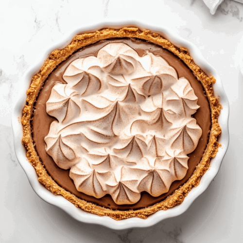 this image shows the meringue topping is torched to achieve a golden brown finish, adding a beautiful caramelized texture to the Vegan Chocolate Meringue Pie.