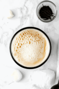 This image shows aquafaba being whipped to stiff peaks in a mixing bowl, creating a light and airy meringue for the vegan lemon pie.