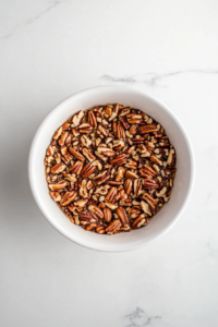 This image shows whole pecans being meticulously arranged on top of the pecan filling, creating an elegant pattern.