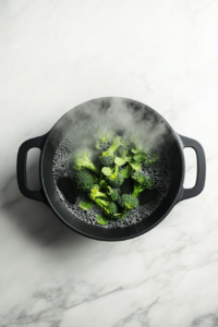 This image shows fresh broccoli florets being added to the boiling pasta water, allowing them to cook together for a well-balanced dish.